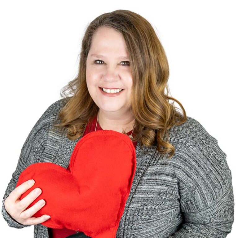 Woman, Julie, smiling and holding the Variety Heart.